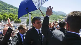 Los guardaespaldas protegen al primer ministro serbio de las pedradas con un paragüas.