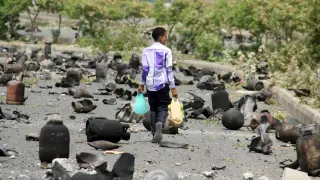 Un niño camina por la calle tras los bombardeos.