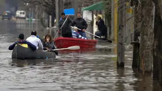 Habitantes navegan por las calles inundadas en Luján, Buenos Aires.