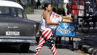Una mujer camina por las calles de La Habana con un pantalón con la bandera de EE. UU.