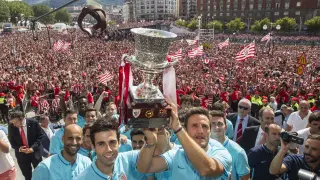 El capitán Carlos Gurpegui (c), sujeta el trofeo junto al resto de los jugadores del Athletic ante miles de personas.