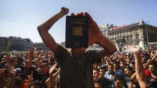 Un inmigrante muestra su pasaporte durante una manifestación espontánea frente a la Estación de Trenes Oriental en Budapest.