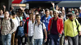 Varios refugiados saludan a su llegada a la estación de Munich.