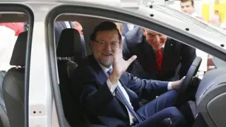 El presidente del Gobierno, Mariano Rajoy, junto al presidente de SEAT, Jürgen Stackmann, saluda desde el interior de un prototipo