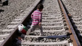 Un niño cruza las vias del tren.