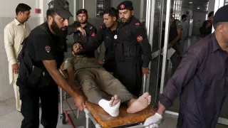 Equipos sanitarios evacúan a un herido en el ataque talibán a la base militar pakistaní.