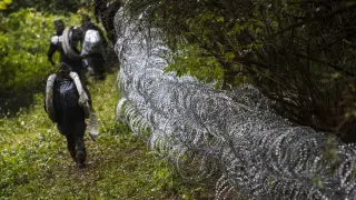 Varios soldados húngaros levantan una alambrada en la frontera con Croacia.