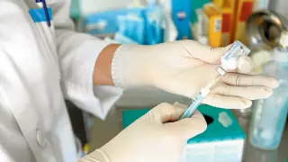 Una profesional sanitaria prepara una vacuna para su posterior inyección.