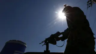 Un oficial de seguridad afgano vigila en un puesto de control en Herat
