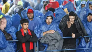 Los refugiados se protegen de la intensa lluvia con tiendas de campaña, lo más afortunados, o con chubasqueros.