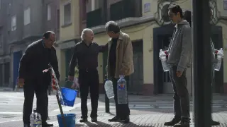 Varios vecinos recogían agua del grifo habilitado para paliar la afección en la esquina de la calle de Ávila, este domingo a mediodía.