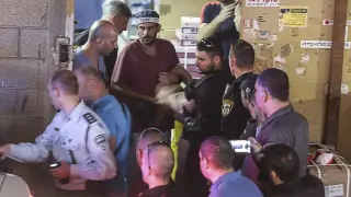 Agentes de policía detienen a un palestino en el lugar del ataque perpetrado en Tel Aviv.