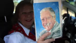 Una mujer muestra una foto de Pinochet.