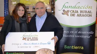 Jana Catalán, directora de la Fundación Caja Rural de Aragón en el momento de la entrega solidaria a José Ignacio Alfaro, presidente del Banco de Alimentos de Zaragoza.