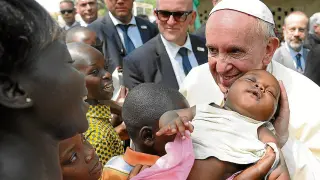 Francisco sonríe a una madre y su bebé, ayer en Bangui (República Centroafricana) .