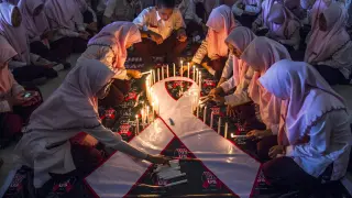 Estudiantes indonesios encienden velas durante un acto conmemorativo del Día Mundial de la lucha contra el sida.