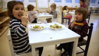 Los niños comen judía verde con patata y salteado de hamburguesa de espelta.