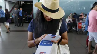 Una turista con un manual sobre el virus Zika