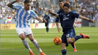 El centrocampista del Real Madrid, 'Isco' se dispone a chutar ante el defensa del Málaga Raúl Albentosa.