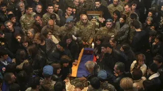 Decenas de personas rodean el féretro de un soldado armenio muerto.