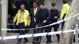 Policía y miembros del Samur acompañan al hombre herido tras sorprender a dos ladrones robando en una vivienda de Madrid.