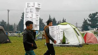 Dos refugiados del campo de Idomeni, entre Grecia y Macedonia, con ayuda de Arapaz.