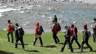 Un grupo de voluntarios, guiados por un forestal, inicia la búsqueda por las orillas del río.