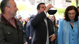 El secretario del PSOE CyL, Luis Tudanca (c), bebe de un porrón, junto al presidente de ASAJA, Donaciano Dujo (i), y la subdelegada del Gobierno, María José Heredia (d), durante la inauguración de la 56ª Feria de Muestras de Almazán