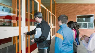 El profesor de educación física del Guillermo Fatás abre la puerta del pabellón a sus alumnos.