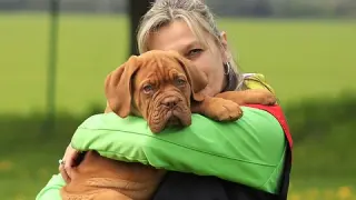 Una mujer abrazando a su perro.