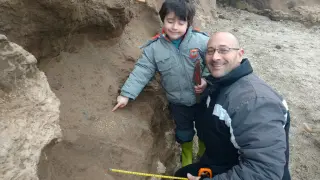 El pequeño argentino, junto a su padre,muestra los restos que encontró