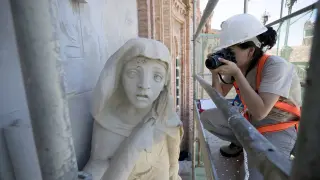 Una restauradora toma fotos del relieve de Los Amantes.