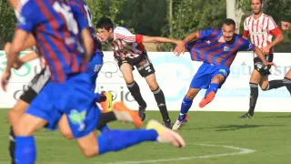 David Ferreiro, de la SD Huesca, sufre el agarrón de un jugador rival.