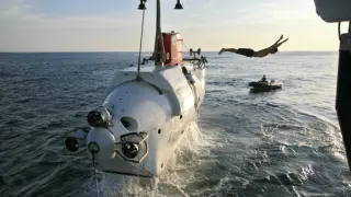Alvin es un sumergible tripulado para la investigación oceánica profunda, de la Marina de los Estados Unidos. En la imagen, un miembro de la tripulación se lanza al agua después de asegurar el submarino a su buque de soporte.