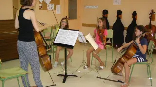 La profesora de violoncello practicando con varias alumnas.
