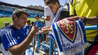 Zapater firma  autógrafos a unos jóvenes seguidores zaragocistas tras un entrenamiento en La Romareda.