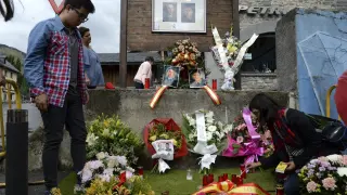 Unos jóvenes depositan flores y velas en recuerdo de Irene Fernández y José Ángel de Jesús.