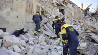 Varios bomberos trabajan entre los escombros en Pescara del Tronto