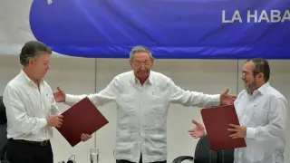 El presidente colombiano Santos (izquierda) y Timochenko (derecha), con Raúl Castro en el centro