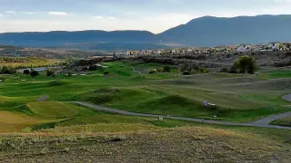 El campo de golf de Badaguás, ayer, que necesita una remodelación. Al fondo, la urbanización.