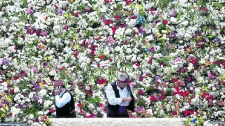 Los jardineros municipales, con el traje tradicional, arropados por el manto floral de la Virgen.