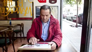Perico Fernández contempla una de sus pinturas en un restaurante zaragozano en 2011.