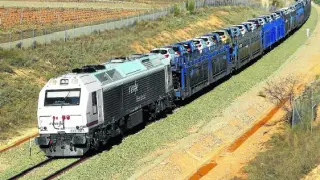 Un tren cargado de coches de la planta de GM , entre Longares y Cariñena, en su viaje a Valencia.