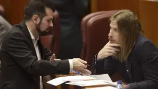 Los portavoces de los grupos parlamentarios del PSOE y del PP, Luis Tudanca (i), y Pablo Fernández (d), conversan durante la sesión plenaria