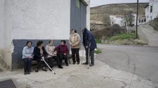 Un grupo de vecinos de Bueña, en el lugar donde cogen el taxi para ir a Monreal del Campo.
