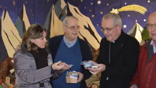 Raúl Revilla, capellán del Centro Penitenciario de Zuera -en el centro de la imagen-, coordina la entrega de las tarjetas telefónicas junto a una voluntaria y monseñor Pérez Pueyo.
