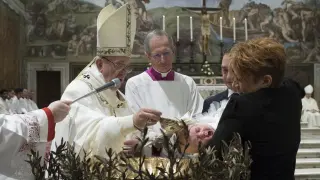 El papa Francisco bautizando a uno de los 28 niños y niñas.