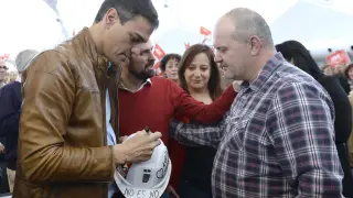 El exsecretario general del PSOE y candidato a las Primarias, Pedro Sánchez, firma un casco como gesto de apoyo al carbón autóctono de un minero leonés, que ha acudido al acto celebrado hoy en Valladolid.
