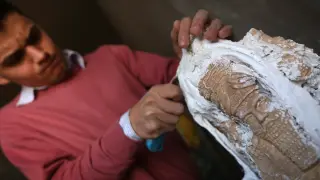 Un joven iraquí restaurando una pieza dañada.