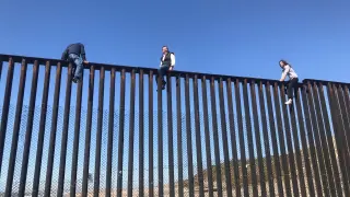 El diputado mexicano Braulio Guerra, sentado en lo alto del muro que separa la frontera entre Estados Unidos y México.